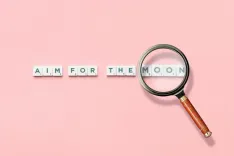 Phrase and Magnifying Glass on Pink Background 